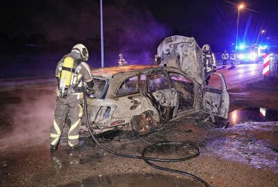 Mercedes fängt Feuer während der Fahrt: C-Klasse völlig ausgebrannt - Als die Freiwillige Feuerwehr Wilsdruff eintraf, stand das Auto lichterloh in Flammen. Mit einem Strahlrohr löschten die Feuerwehrleute den Brand. Foto: Roland Halkasch