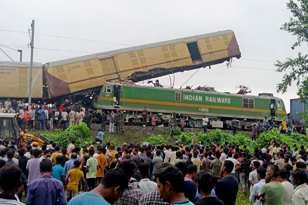 Mindestens 15 Tote bei Zugunglück in Indien - Schaulustige beobachten die Arbeit von Rettungskräften, nachdem ein Güterzug in der Nähe des Bahnhofs von New Jalpaiguri im indischen Bundesstaat Westbengalen einen Personenzug gerammt hat.