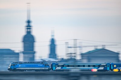 Mit diesen 5 Tipps werden Zugreisen günstiger und relaxter - Ein Eurocity-Zug fährt durch Dresden: Auf länderübergreifenden Verbindungen kann es sich lohnen, die Angebote auf den Websites der jeweiligen Landesbahnen zu checken.