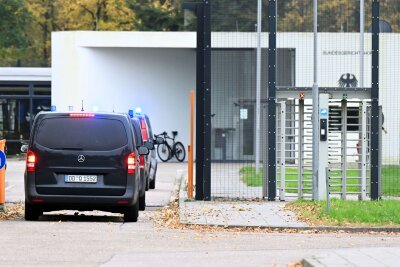 Mutmaßlicher Anführer linksextremistischer Gruppe in U-Haft - Mit eingeschaltetem Blaulicht fahren mehrere Wagen auf den Hof an der Außenstelle des Bundesgerichtshofs. 