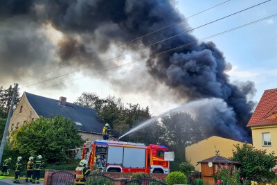 Feuerwehrkräfte und Tanklöschfahrzeuge kämpfen gegen die riesige Rauchwolke, die über Forchheim aufsteigt. Foto: EHL Media/Dietmar Thomas