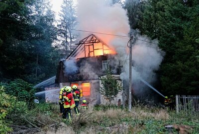 Nach tödlichem Hausbrand in Auerswalde: Ursache und Opfer weiter unbekannt - Ein Haus im Vollbrand, in sehr unwegsamem. Foto: Harry Härtel