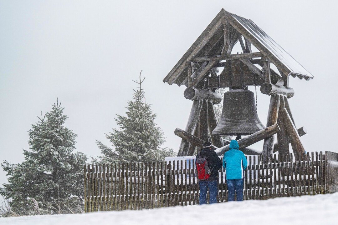 Neue Friedensglocke auf Fichtelberg erstmals erklungen - Zwei Wanderer stehen vor der Friedensglocke auf dem Fichtelberg. (Archivbild)