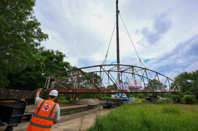 Neuer Rastplatz am Chemnitztalradweg: Historische Brücke mit Kran umgesetzt - Die als technisches Denkmal erhaltene, historische Fischwegbrücke wurde am heutigen Donnerstag mit einem Kran an ihren neuen Standort am zukünftigen Rastplatz am Chemnitztalradweg versetzt.