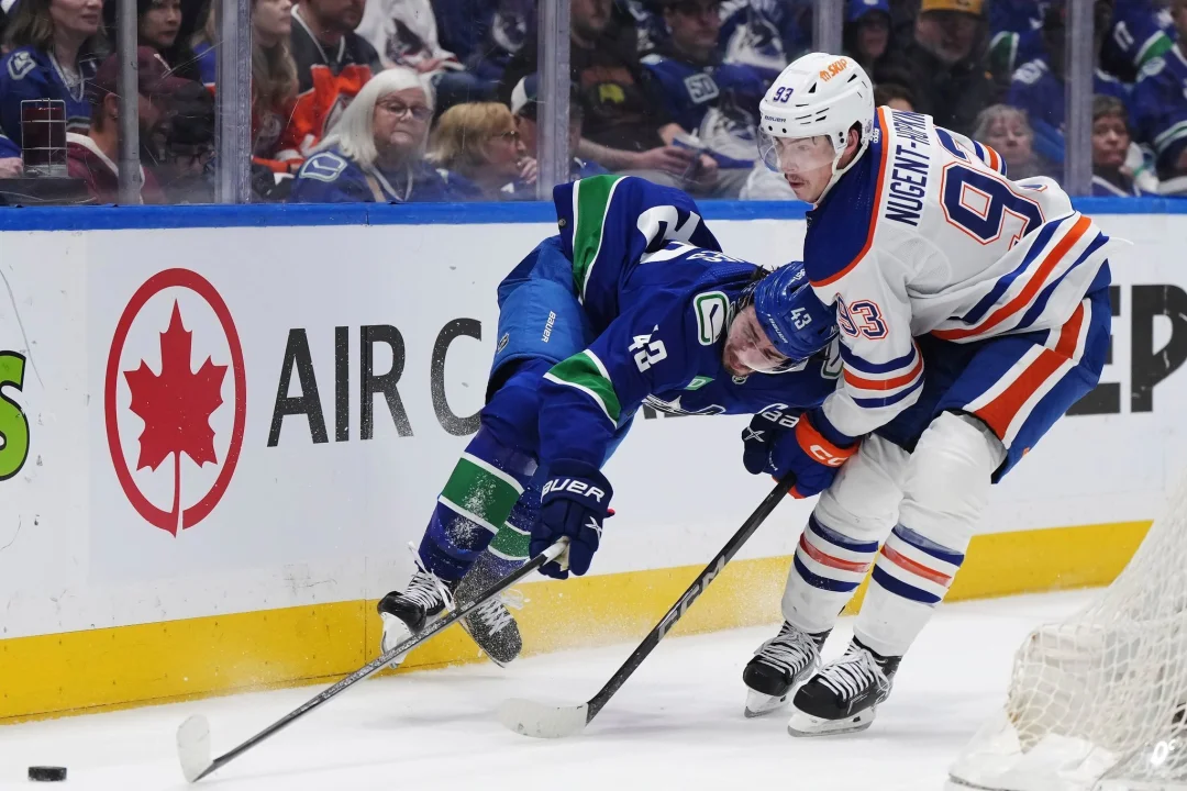 Oilers verlieren gegen Canucks - Draisaitl angeschlagen - Quinn Hughes von den Vancouver Canucks wird von Ryan Nugent-Hopkins von den Edmonton Oilers zu Fall gebracht.