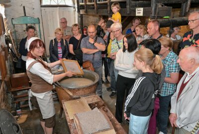 Papierschöpfen und mehr: Großer Andrang zum Mühlentag im Erzgebirge - In der Papiermühle haben Besucher die traditionelle Papierherstellung hautnah erleben können - Museumsmitarbeiterin Antje Henkel-Schilbach hat das Papierschöpfen demonstriert. Foto: Ralf Wendland