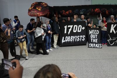 Party der Öl-Industrie? 1.700 Lobbyisten auf Klimagipfel - Lobbyisten als böse Schlange: Aktion von Klimaaktivisten auf der COP29.