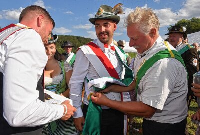 Photovoltaik-Monteur steht im Lichte des Schützenkönigs - Schützenkönig Felix Säuberlich bekommt von David und Arndt Kutzke, rechts, die Insignien der Macht überreicht. Foto: Christof Heyden