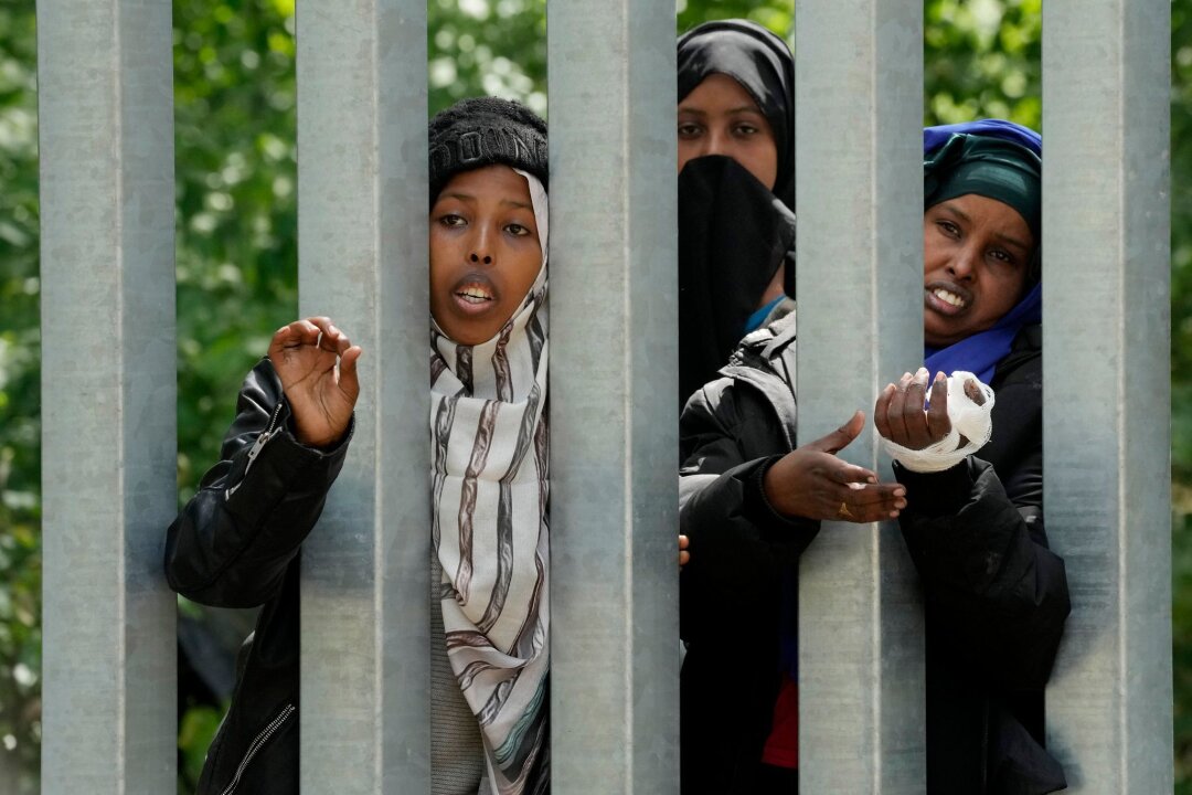 Polen plant Aussetzung des Asylrechts an Grenze zu Belarus - Migratinnen an der Grenzbarriere, die Polen entlang der Grenze zu Belarus errichtet hat. Warschau wil das Recht auf Asyl aussetzen. (Archivbild)