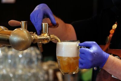 Prag verbietet nächtliche organisierte Kneipentouren - Ein Barkeeper zapft ein Bier auf einer Restaurant-Terrasse. (Symbolbild)