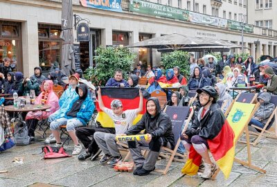 Public Viewing in der Chemnitzer City: Fußballfans trotzen dem Regen - Trotz des ungemütlichen Regenwetters ließen es sich die begeisterten Fans nicht nehmen, das spannende Spiel der deutschen Mannschaft gegen Ungarn auf der großen Leinwand zu verfolgen. Foto: Harry Härtel