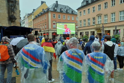 Trotz des ungemütlichen Regenwetters ließen es sich die begeisterten Fans nicht nehmen, das spannende Spiel der deutschen Mannschaft gegen Ungarn auf der großen Leinwand zu verfolgen. Foto: Harry Härtel