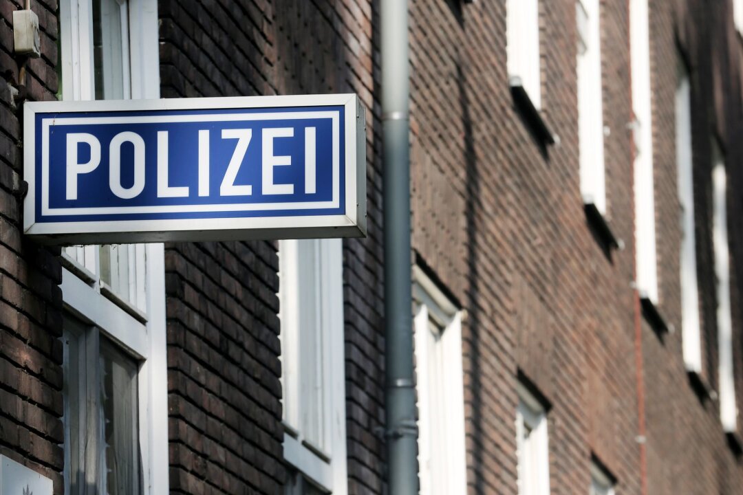 Rassistische Parolen zu Partyhit - Vorfall auch in Sachsen - Ein Schild mit der Aufschrift "Polizei" hängt an einem Polizeipräsidium.