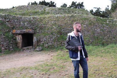 Robinson-Gefühle in Frankreichs Schärengarten - Guide Clément Legrand vor dem Cairn de Gavrinis - der unscheinbare Eingang führt in eine Welt kunstvoll verzierter Steinwände.