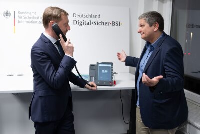 Sachsen möchte Cyber-Abwehr ausbauen - Ministerpräsident Michael Kretschmer (l) informierte sich über eine hochsichere Telefonie-Lösung. 