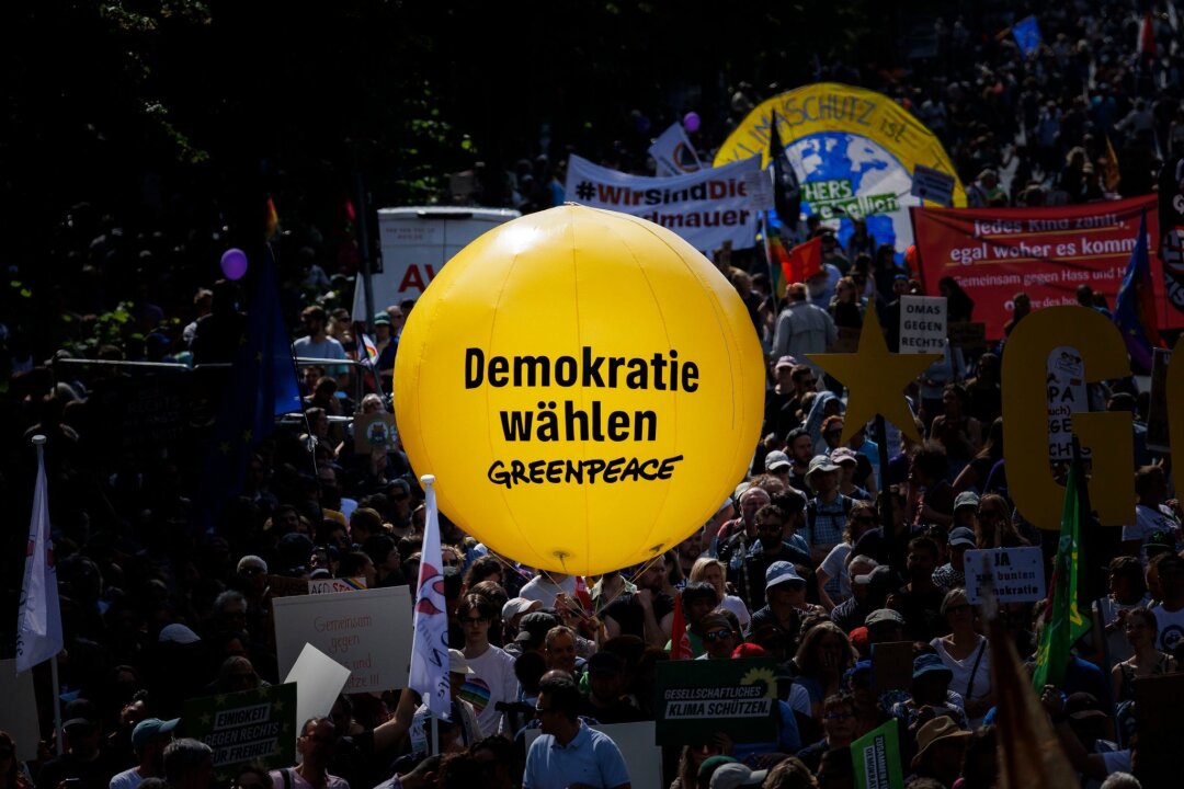 Sachsen-SPD enttäuscht vom Ergebnis der Europawahl - Teilnehmer halten einen gelben Ballon von Greepeace mit dem Text "Demokratie Wählen" bei einer Demonstration an der Siegessäule am Tag vor den Europawahlen gegen Rechtsextremismus und für eine demokratische, offene und vielfältige Gesellschaft.