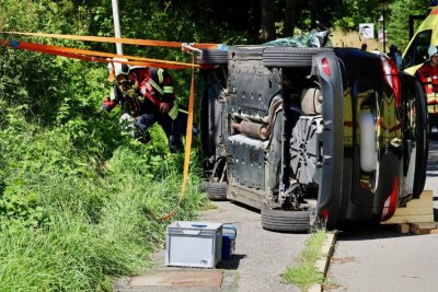 Der verunglückte Renault liegt nach dem Aufprall gegen eine Laterne auf der Seite. Die Talstraße in Waschleithe ist derzeit gesperrt. Foto: Niko Mutschmann