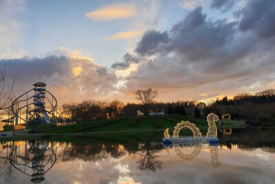 Sonnenuntergang über dem Teich des Sonnenlandparks. Im Hintergrund der große Rutschenturm.