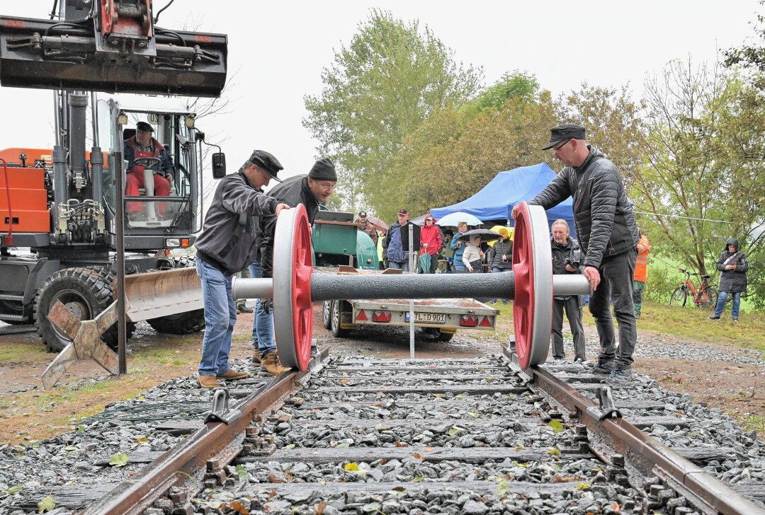 Speicherradsatz bereichert Eisenbahn-Erlebnispfad im Erzgebirge - Beim Aufsetzen des Speicherradsatzes auf das Gleis (v.li.) Jens Hanisch, Jens Hahn und Mike Robeck (v.li.) von der Interessengemeinschaft Zwönitz-Scheibenberg. Foto: Ramona Schwabe