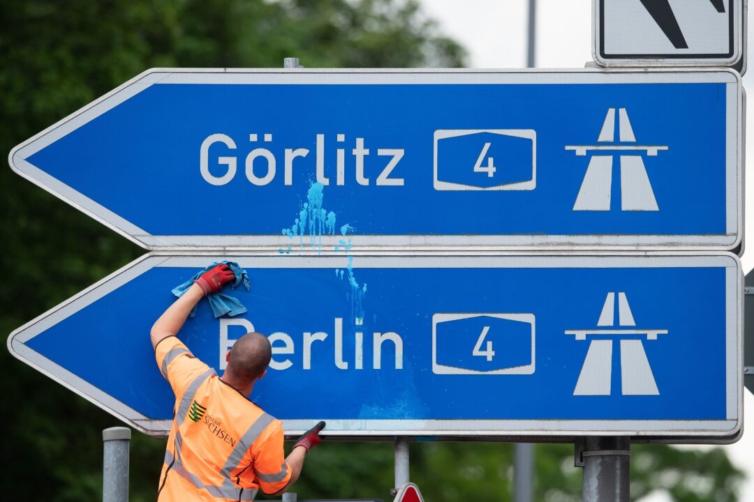 Sperrungen an mehreren Orten auf der A4 am Mittwoch - Ein Mann reinigt das blau-weiße Schild der Autobahnauffahrt A4 Richtung Berlin und Görlitz.