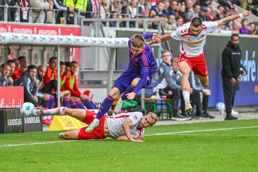 Spitzenreiter Düsseldorf gewinnt bei Schlusslicht Regensburg - Der Düsseldorfer Isak Johannesson im Zweikampf mit den Regensburgern Louis Breunig (l) und Rasim Bulic.