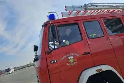 Die Feuerwehr Köthensdorf von der Seite, ein Fahrer schaut raus und lächelt.