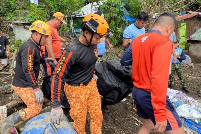 Tropensturm "Trami" verwüstet Philippinen - Mehr als 80 Tote - Rettungskräfte bergen eine Leiche nach einem Erdrutsch, der durch den Tropensturm Trami ausgelöst wurde 