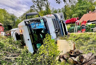 Unfall enger Talstraße in Sachsen: Müllwagen stürzt in Garten - Der Beifahrer wurde dabei leicht verletzt. Foto: Marko Förster