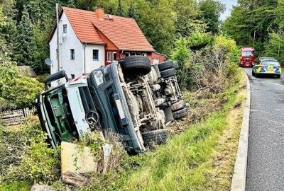 Unfall enger Talstraße in Sachsen: Müllwagen stürzt in Garten - Beim Versuch dem entgegenkommenden LKW auszuweichen, stürzte der Müllwagen in einen Garten ab. Foto: Marko Förster