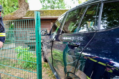 Eine Fahrerin war mit ihrem BMW vom Parkplatz aus durch einem Zaun gefahren und kam an einem Gartenhaus nach dem Zaun zum stehen. Foto: Niko Mutschmann