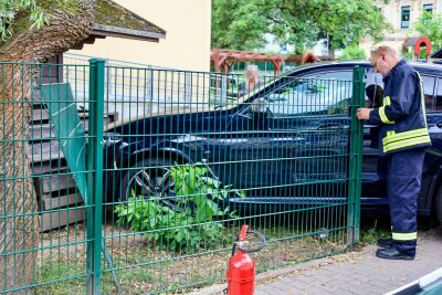 Eine Fahrerin war mit ihrem BMW vom Parkplatz aus durch einem Zaun gefahren und kam an einem Gartenhaus nach dem Zaun zum stehen. Foto: Niko Mutschmann