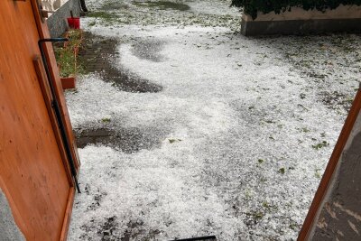 Unwetter über kleinem Dorf im Landkreis Zwickau: Hagel und Schlamm sorgen für Feuerwehreinsatz - Hagel verwandelte den Boden in eine weiße Winterlandschaft.