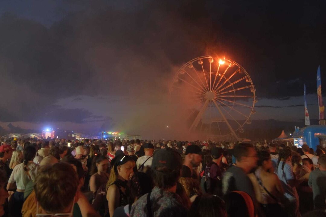 Update: Highfield Festival unterbrochen: Riesenrad in Flammen - Erste Erkenntnis zur Ursache - Das Riesenrad auf dem Highfield Festival steht in Flammen.