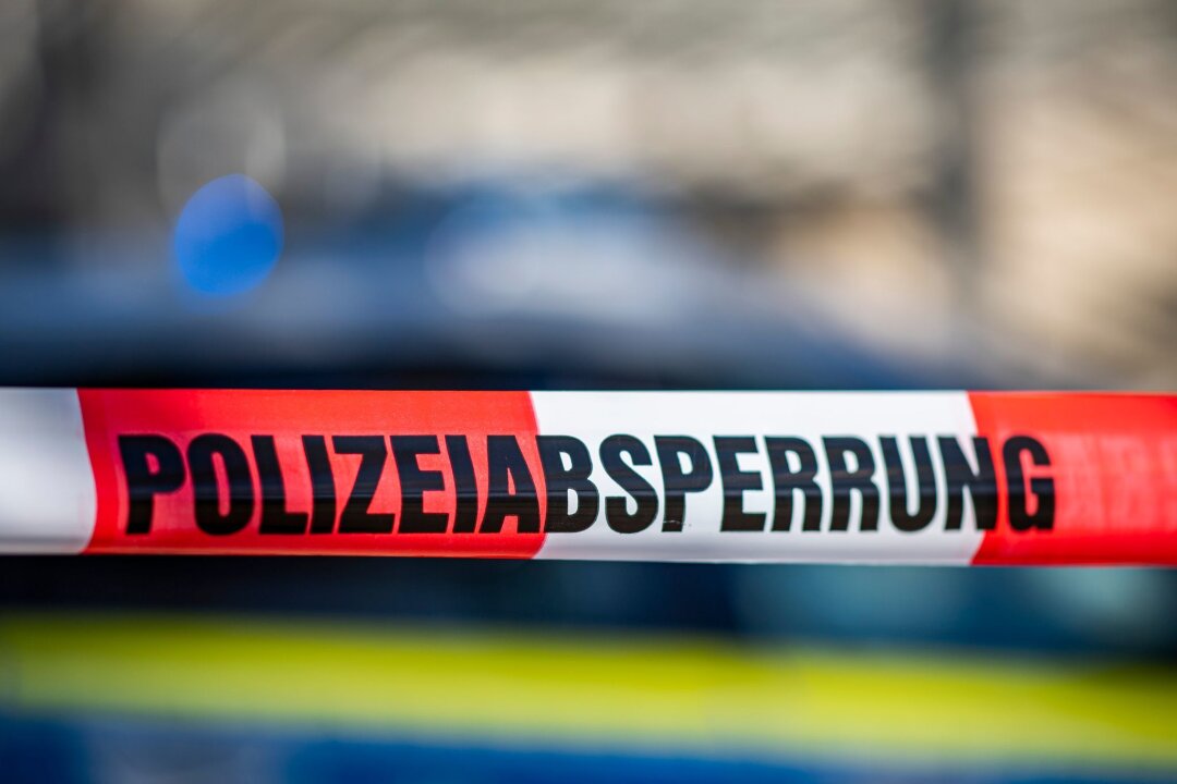Update: Lebloser Mensch in Bischofswerda identifiziert - Polizei ermittelt - Ein Absperrband mit der Aufschrift "Polizeiabsperrung" ist vor einem Polizeiwagen aufgespannt.