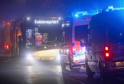 Update zu Starke Rauchentwicklung bei Brand in Leipzig: Zwei Verletzte - Die evakuierten Bewohner des Hochhauses kamen in einem Bus der Leipziger Verkehrsbetriebe unter, um eine Unterkühlung zu vermeiden. Foto: EHL Media/Björn Stach