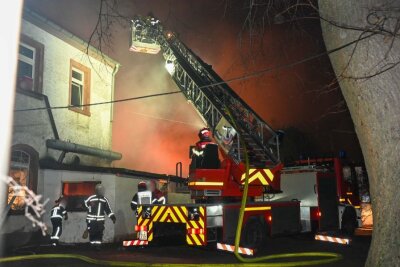 Feuerwehrleute im Großeinsatz: Mit Atemschutz und Drehleiter kämpften die Einsatzkräfte gegen die Flammen, die durch starken Wind immer wieder aufgefacht wurden. Foto: EHL Media/Dietmar Thomas/Michel Köhler