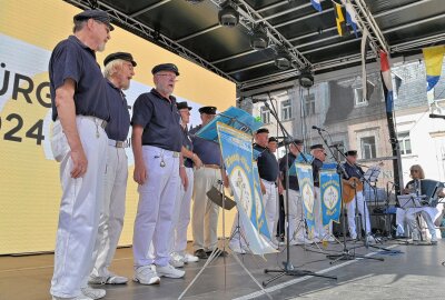 Warum sich 102 Seemänner und Seefrauen auf dem Schneeberger Marktplatz eingefunden haben - Auf der Bühne stand der Shanty-Chor der Marinekameradschaft Plauen. Foto: Ramona Schwabe