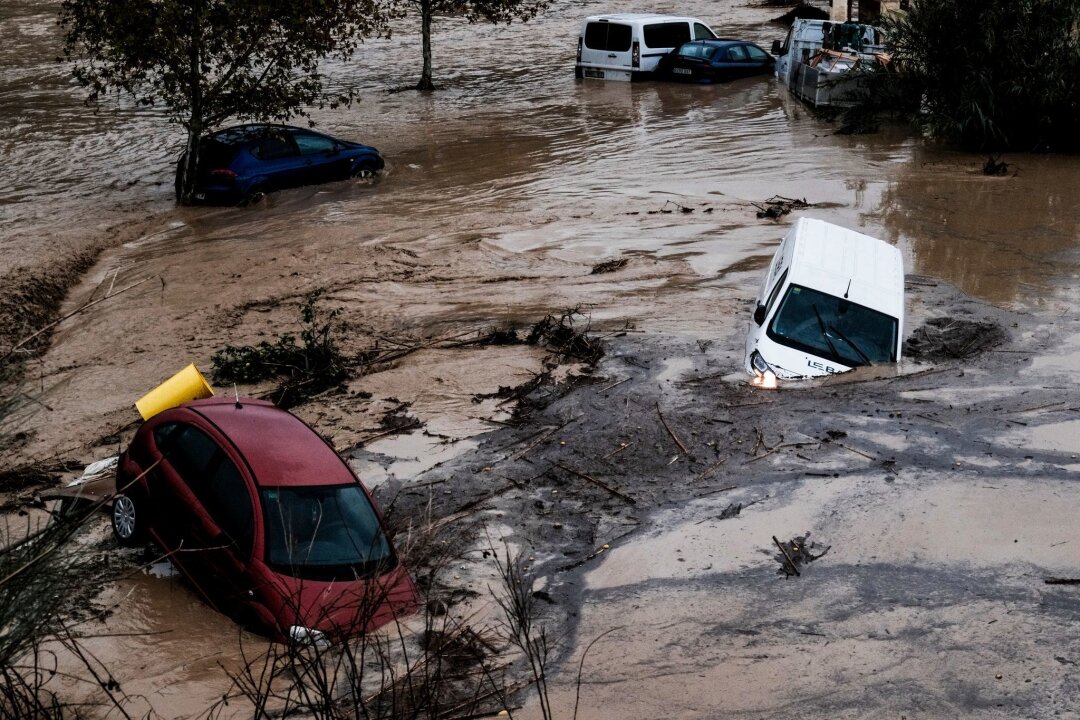 Weggespülte Autos und entgleister Schnellzug in Spanien - Autos und Bäume wurden bei den Überschwemmungen wie Spielzeug mitgerissen.