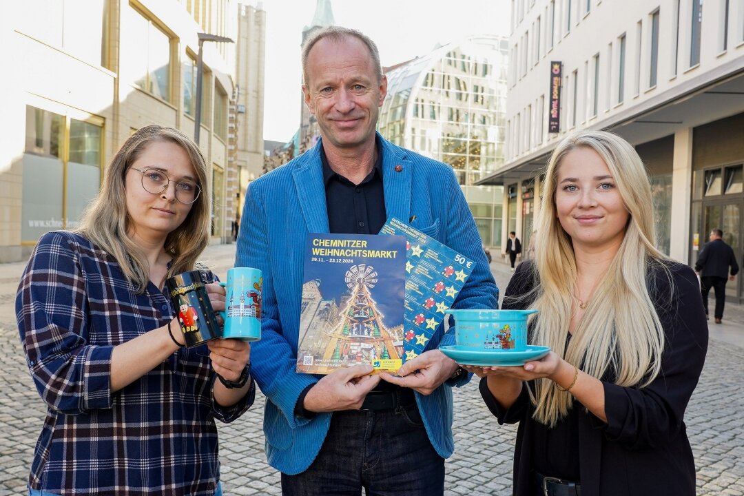 Weihnachtszauber zum Sammeln: Die neuen Tassen des Chemnitzer Weihnachtsmarkts 2024 - Kathleen Herold (SG Märkte), Bürgermeister Knut Kunze, Lucy Auerbach (SG Märkte) präsentieren das neue Weihnachtsgeschirr 2024.