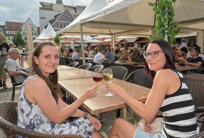 Weindorf Zwickau öffnet auf dem Hauptmarkt - Das Weindorf in Zwickau lädt auch in diesem Jahr wieder zum Verweilen ein. Eine Impression aus dem Vorjahr: Melanie Igel aus Zwickau und Dorothea Liebich aus Zwickau (v.l.). Foto: Ralf Wendland/Archiv