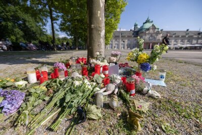Weitere Ermittlungen nach Angriff in Bad Oeynhausen - Blumen, Kerzen und handgeschriebene Trauerbekundungen an einem Baum im Kurpark Bad Oeynhausen.