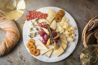 Wie ein Schweizer Uhrwerk: So wird die Käseplatte perfekt - Eine Käseplatte nach der Uhr gestellt: Um 12 Uhr beginnt es mild mit Tête de Moine, wird mit Emmentaler, Le Gruyere und Appenzeller immer herzhafter und schließt zwischen 9 und 11 Uhr mit würzigem Blauschimmelkäse. Trauben, Birnenspalten, Thymian, Rote-Bete- und Brezel-Chips lockern die Platte auf. 