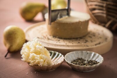 Wie ein Schweizer Uhrwerk: So wird die Käseplatte perfekt - Mit der sogenannten Girolle, einem kurbelähnlichen Käsehobel, wird der Tête de Moine hauchdünn geschnitten. Raffinierter wird es, wenn der Mönchskäse schon vor dem Hobeln mit schwarzem Pfeffer bestreut wird.