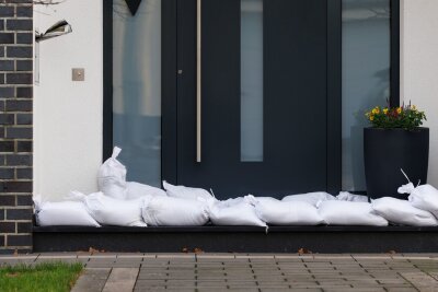 Wie schütze ich mein Haus vor Hochwasser? - Sandsäcke vor Fenstern und Türen aufzustapeln ist eine einfache und wirksame Methode, um bei Regen Wassereinbruch in den Keller zu verhindern.