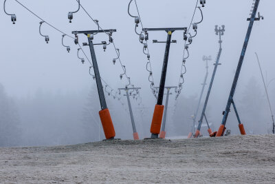 Winterauftakt im Erzgebirge: Schnee auf Fichtelberg und Winterdienst im Einsatz - Touristen und Touristinnen brauchten diesmal eine dicke Jacke, Mütze und einen Schal. Einige Gäste genießen bereits den ersten Schnee.