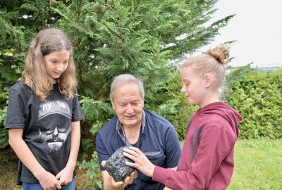 Wo Kinder im Erzgebirge in den Ferien Spaß haben und etwas Lernen können - Gästeführer Ulrich Neubert (Mitte) zeigt Mia Straßinger (li.) und Leni Straßinger ein Stück Kohle. Foto: Ralf Wendland