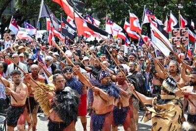 Zehntausende bei Maori-Protesten in Neuseeland - Demonstranten tragen die traditionelle Kleidung der indigenen Bevölkerung und präsentieren die Maori-Flagge, 