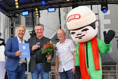 Zschopauer Schlossfest fasziniert vor allem zu später Stunde - Auch das MZ-Maskottchen gratulierte Marcus Schachtschneider, dem Leiter des Enduro-Museums, zu seiner Bürgermedaille. Foto: Andreas Bauer