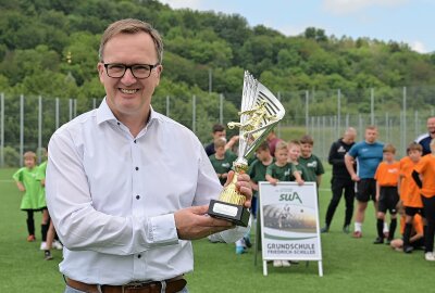 Zschorlauer gewinnen erneut den SWA-Cup - Den Siegerpokal hat Rene Rücker, Geschäftsführer der Stadtwerke Aue-Bad Schlema, an das Team der Grundschule Zschorlau überreicht. Foto: Ramona Schwabe